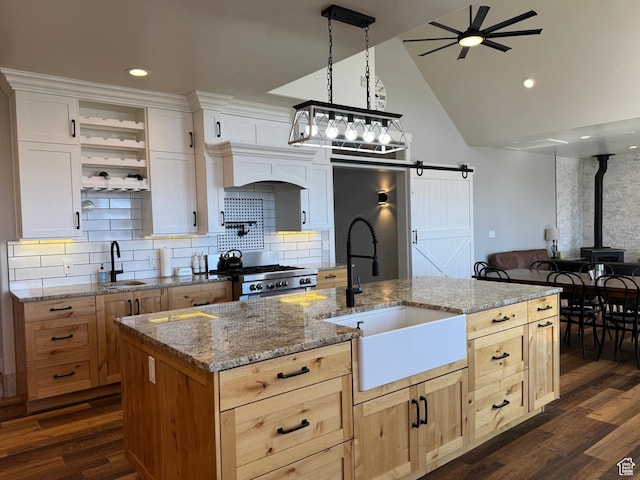 6007 W 8000 S, Payson, UT 84651 - kitchen with a barn door, stove, a sink, white cabinetry, and a center island with sink