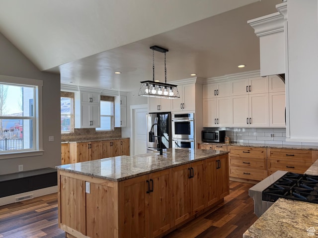 6007 W 8000 S, Payson, UT 84651 - kitchen featuring decorative light fixtures, backsplash, appliances with stainless steel finishes, a kitchen island with sink, and white cabinets