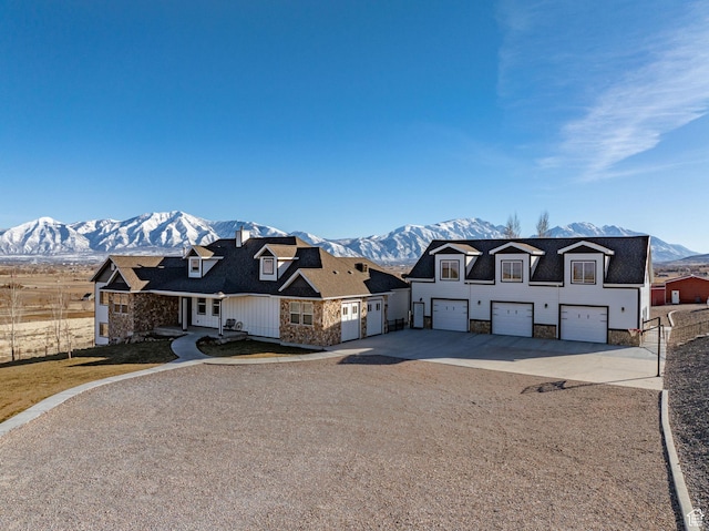view of front facade featuring a garage, concrete driveway, and a mountain view
