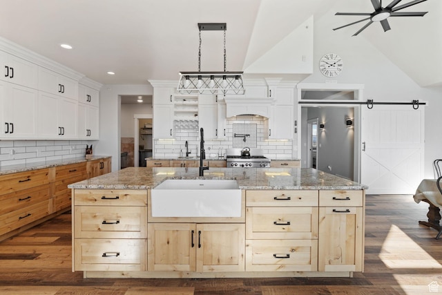 6007 W 8000 S, Payson, UT 84651 - kitchen featuring a barn door, high quality fridge, a kitchen island with sink, hanging light fixtures, and light stone countertops