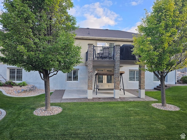 116 E Sandpiper Ln S, Saratoga Springs, UT 84045 - rear view of house with stucco siding, a balcony, a patio, and a yard