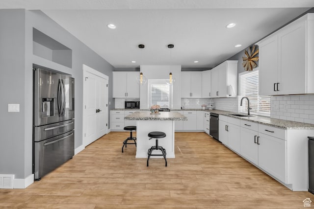 2144 S 120 E, Heber City, UT 84032 - kitchen featuring stainless steel fridge with ice dispenser, a center island, white cabinetry, a breakfast bar area, and tasteful backsplash
