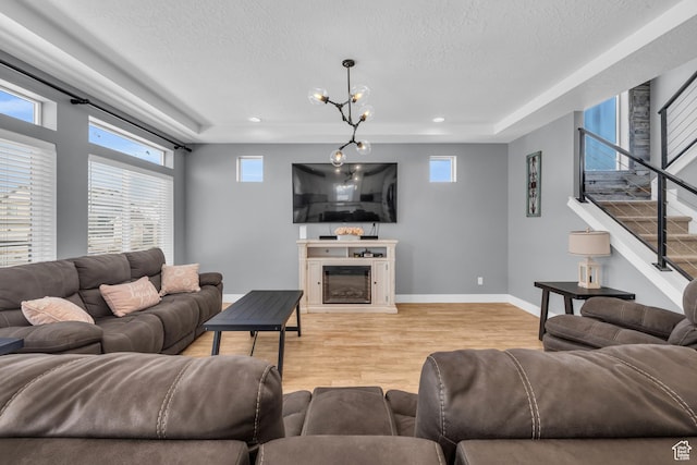 2144 S 120 E, Heber City, UT 84032 - living room featuring light wood finished floors, a textured ceiling, stairway, healthy amount of natural light, and a glass covered fireplace