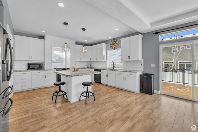 2144 S 120 E, Heber City, UT 84032 - kitchen with dishwasher, a breakfast bar area, healthy amount of natural light, light wood-style floors, and a textured ceiling