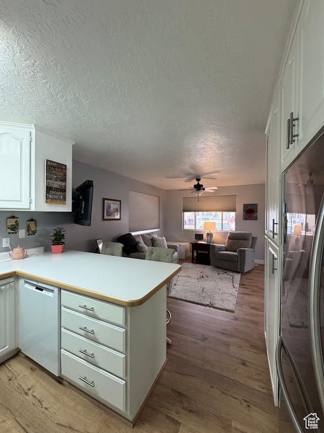 1150 W Red Hills Pkwy Unit 123, Washington, UT 84780 - kitchen featuring white cabinetry, fridge, white dishwasher, kitchen peninsula, and light wood-type flooring