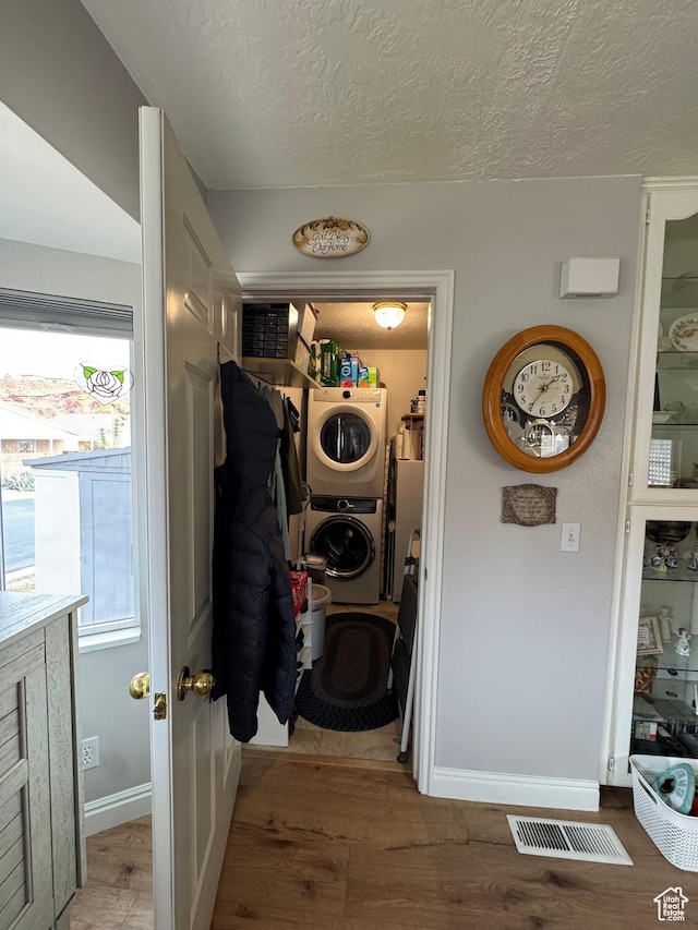 1150 W Red Hills Pkwy Unit 123, Washington, UT 84780 - washroom with stacked washer / dryer, wood-type flooring, and a textured ceiling