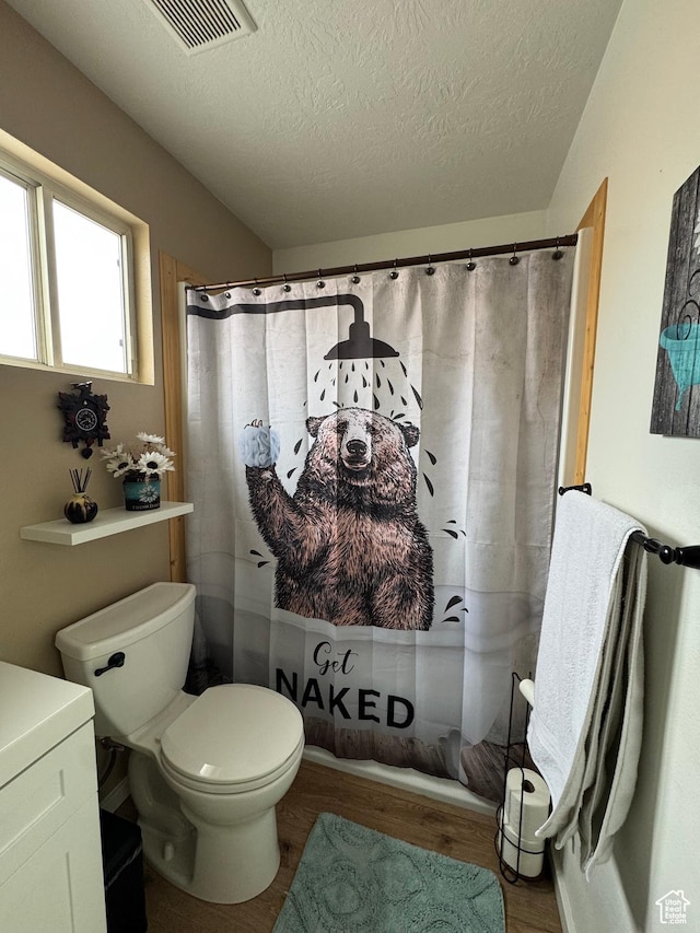 1150 W Red Hills Pkwy Unit 123, Washington, UT 84780 - bathroom featuring a textured ceiling, wood-type flooring, toilet, and walk in shower