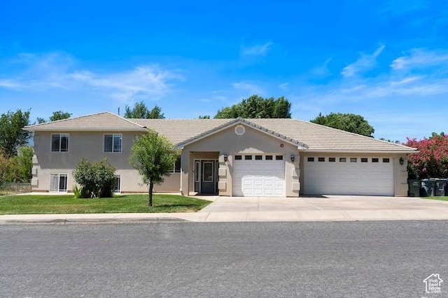 view of front of house with a garage and a front lawn