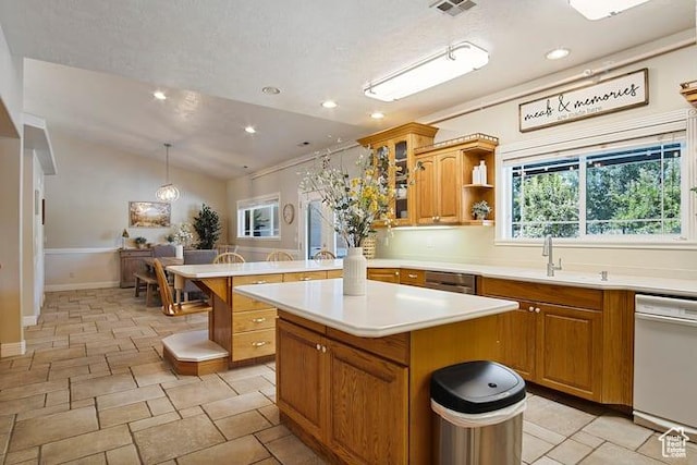 kitchen with dishwasher, lofted ceiling, sink, hanging light fixtures, and a center island