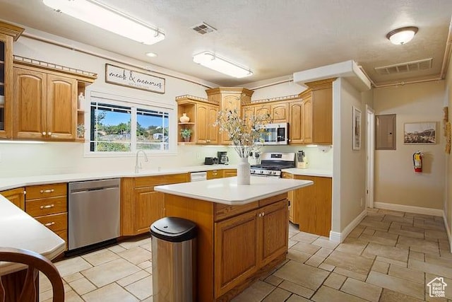 kitchen featuring stainless steel appliances, electric panel, sink, and a kitchen island