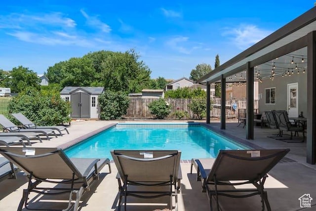 view of swimming pool with a patio area and a storage shed