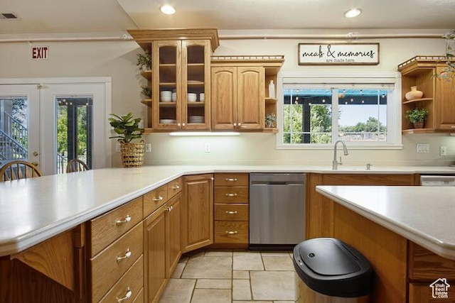 kitchen featuring sink, kitchen peninsula, dishwasher, and a kitchen bar
