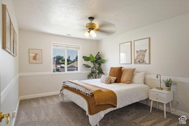carpeted bedroom featuring ceiling fan and a textured ceiling