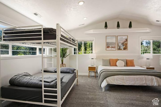 carpeted bedroom with multiple windows, vaulted ceiling, and a textured ceiling