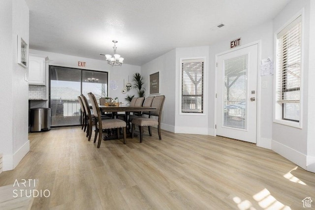 dining space with a notable chandelier and light wood-type flooring