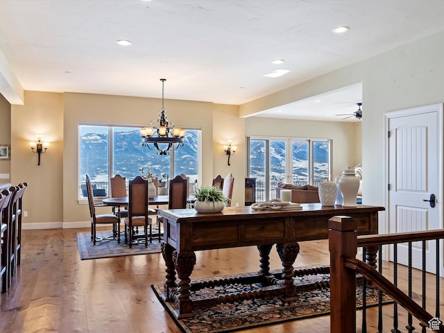 interior space with hardwood / wood-style flooring and ceiling fan with notable chandelier