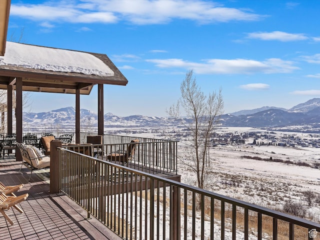 snow covered deck with a mountain view
