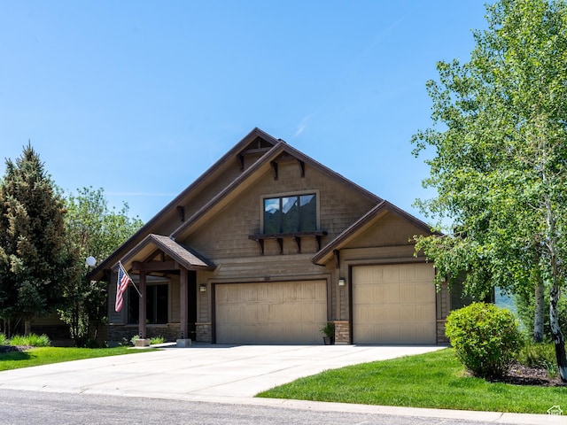5932 E Big Horn Pkwy, Eden, UT 84310 - craftsman inspired home featuring concrete driveway, stone siding, a garage, and a front lawn