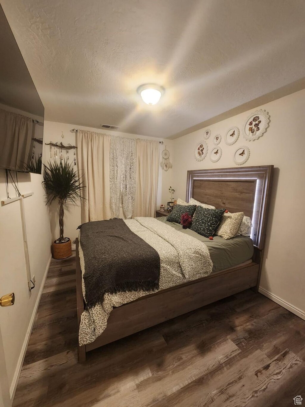 bedroom with dark hardwood / wood-style floors and a textured ceiling