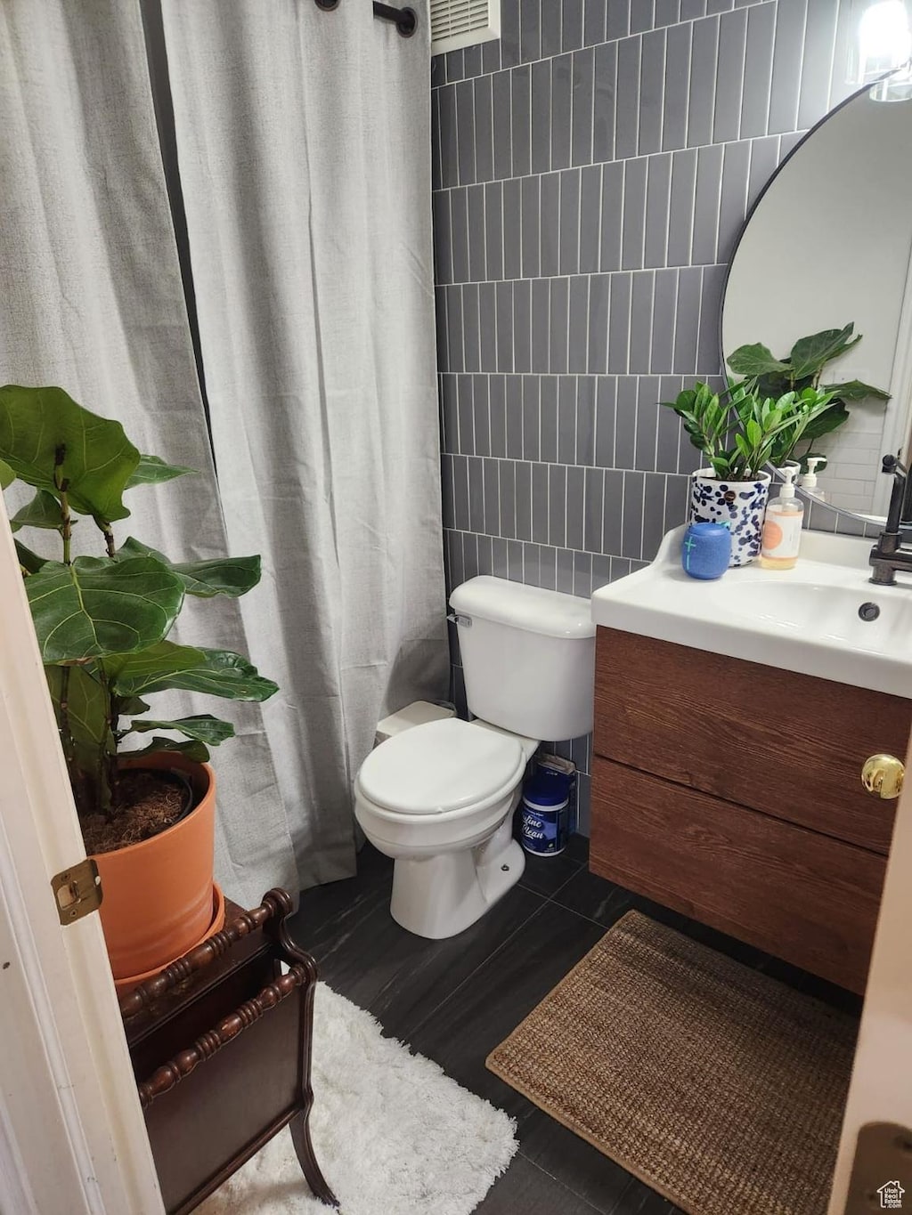 bathroom featuring vanity, tile walls, walk in shower, and toilet