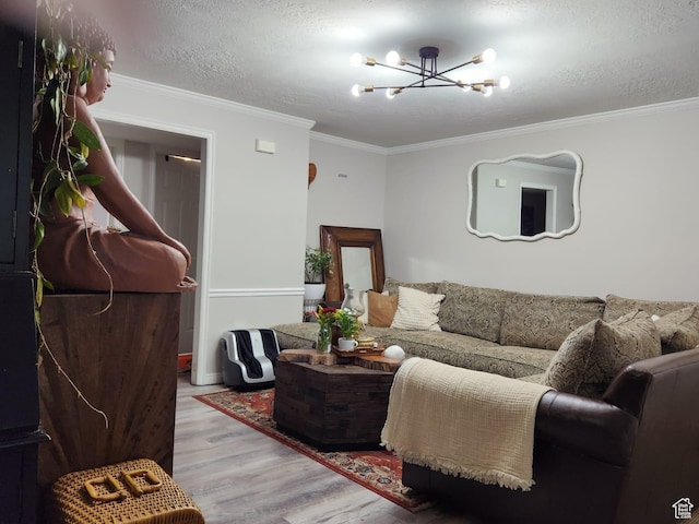 living room with crown molding, a chandelier, a textured ceiling, and light wood-type flooring