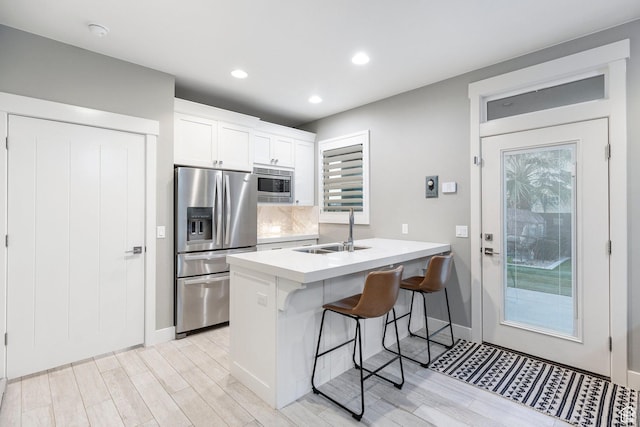2305 E 3350 S, St George, UT 84790 - kitchen featuring a breakfast bar area, light wood-style flooring, a sink, and appliances with stainless steel finishes