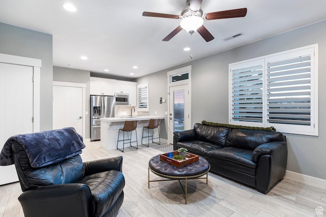 2305 E 3350 S, St George, UT 84790 - living room featuring light wood-style flooring, visible vents, a ceiling fan, and baseboards