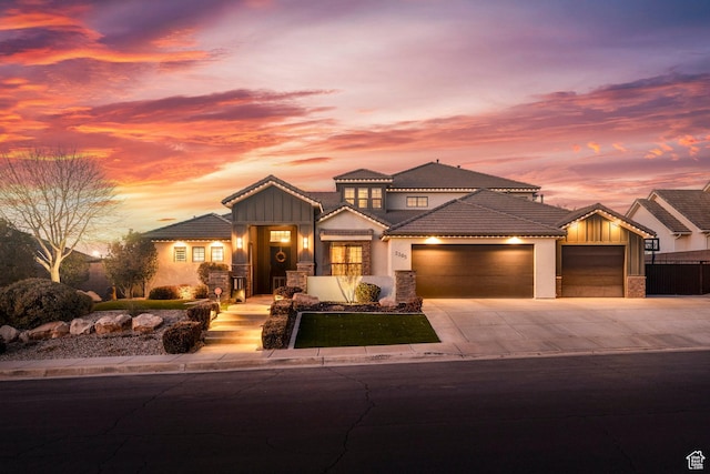2305 E 3350 S, St George, UT 84790 - view of front of house with a tiled roof, stucco siding, an attached garage, driveway, and stone siding