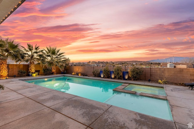 2305 E 3350 S, St George, UT 84790 - pool at dusk featuring a pool with connected hot tub, a patio, a fenced backyard, and a mountain view