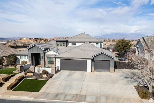 2305 E 3350 S, St George, UT 84790 - view of front of house featuring a tile roof, stone siding, concrete driveway, a garage, and board and batten siding