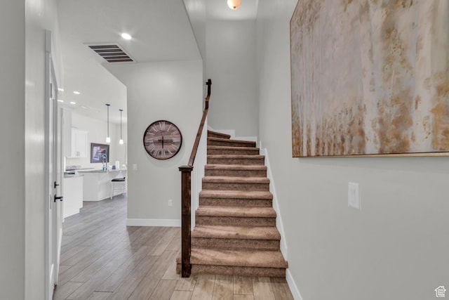 staircase with hardwood / wood-style floors