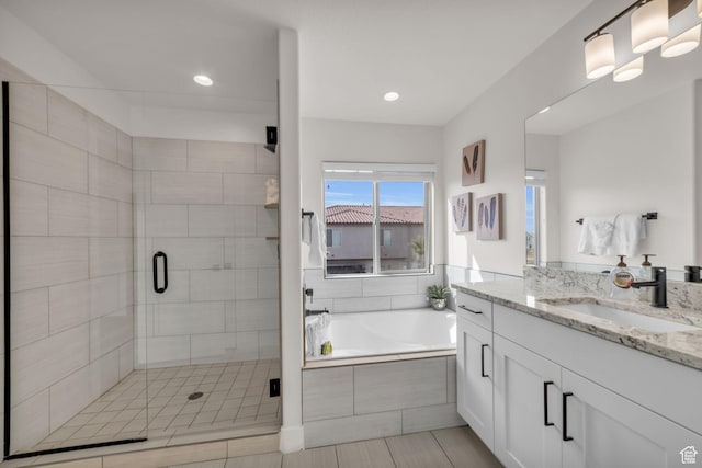 bathroom featuring vanity and shower with separate bathtub