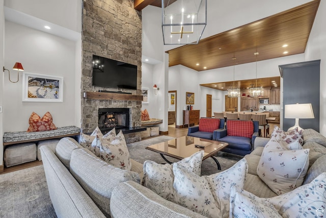 7700 Stein Way Unit 215, Park City, UT 84060 - living room featuring hardwood / wood-style floors, a fireplace, a chandelier, a high ceiling, and wooden ceiling