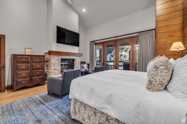 7700 Stein Way Unit 215, Park City, UT 84060 - bedroom with a fireplace, high vaulted ceiling, light hardwood / wood-style flooring, access to outside, and french doors
