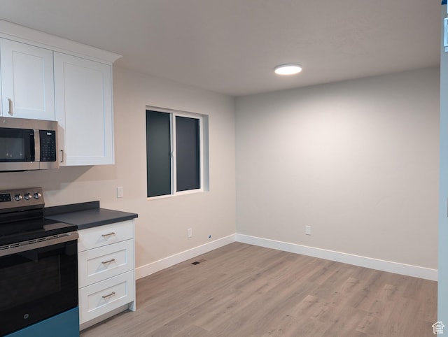 350 W Dublin S, Eureka, UT 84628 - kitchen with light wood-type flooring, white cabinets, appliances with stainless steel finishes, dark countertops, and baseboards