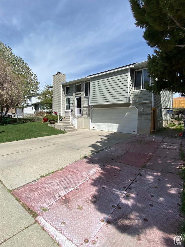 4466 W 6060 S, Salt Lake City, UT 84118 - view of front of house with driveway, an attached garage, a front lawn, a chimney, and brick siding