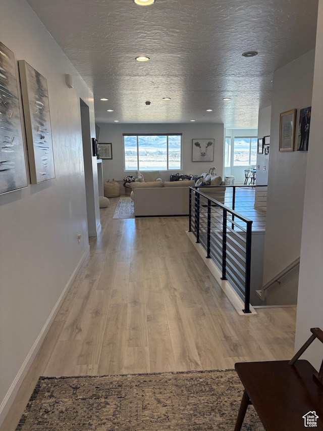 598 S Otto Ln, Grantsville, UT 84029 - corridor featuring light wood-type flooring, baseboards, an upstairs landing, and a wealth of natural light