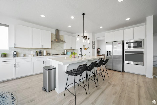 598 S Otto Ln, Grantsville, UT 84029 - kitchen featuring light wood finished floors, wall chimney range hood, backsplash, and stainless steel appliances