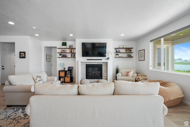 598 S Otto Ln, Grantsville, UT 84029 - living room featuring baseboards, a textured ceiling, recessed lighting, wood finished floors, and a glass covered fireplace