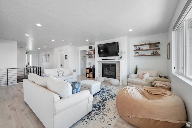 598 S Otto Ln, Grantsville, UT 84029 - living area with a textured ceiling, recessed lighting, a glass covered fireplace, and light wood finished floors