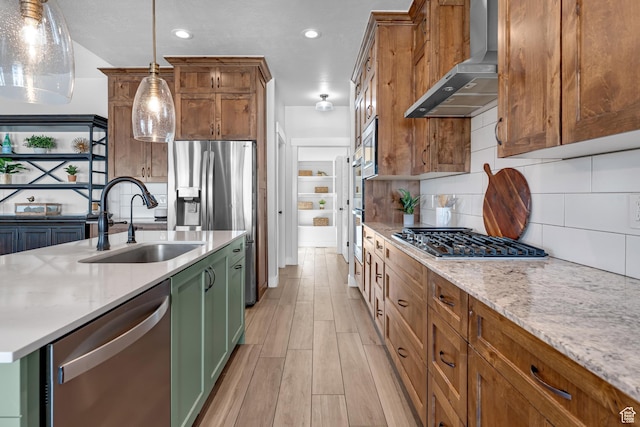 3727 S Larkspur Cir, Saratoga Springs, UT 84045 - kitchen featuring green cabinets, stainless steel appliances, a sink, light wood finished floors, and wall chimney exhaust hood
