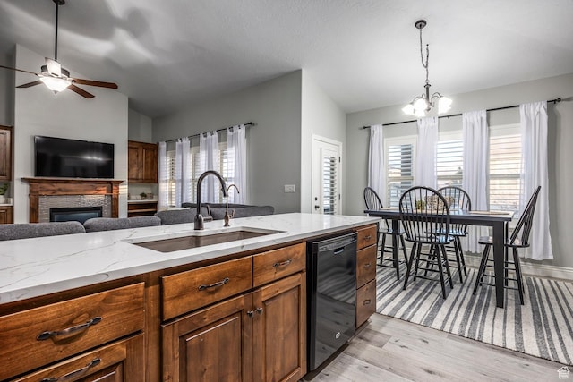 518 N 1980 E, Spanish Fork, UT 84660 - kitchen with dishwasher, a glass covered fireplace, a sink, ceiling fan with notable chandelier, and light wood-style floors