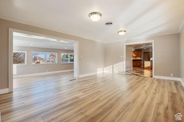 empty room with crown molding and light wood-type flooring