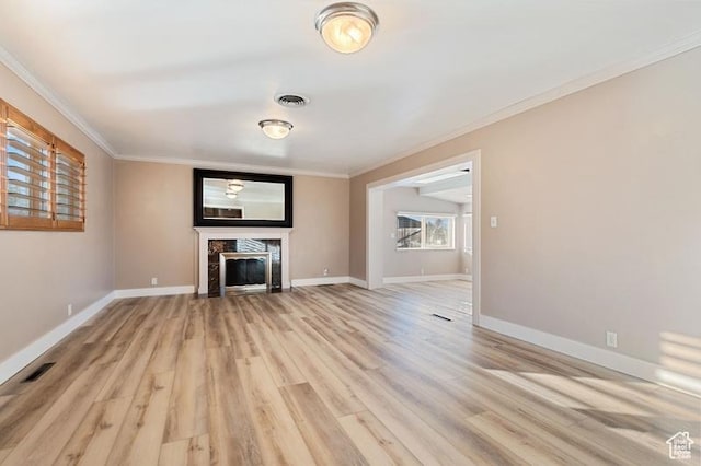 unfurnished living room featuring crown molding, a fireplace, and light hardwood / wood-style floors