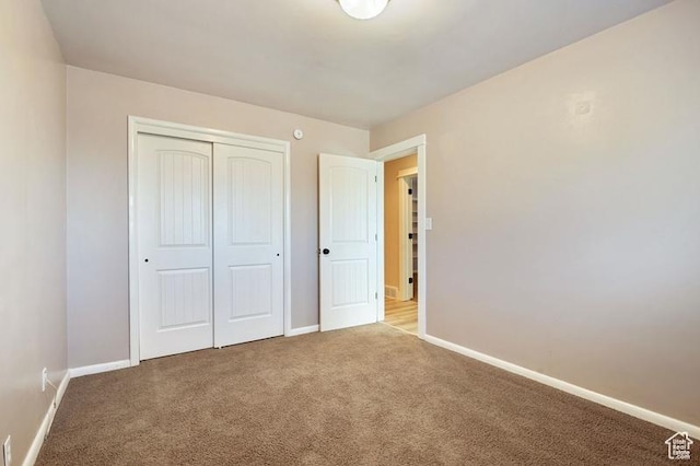 unfurnished bedroom with light carpet and a closet