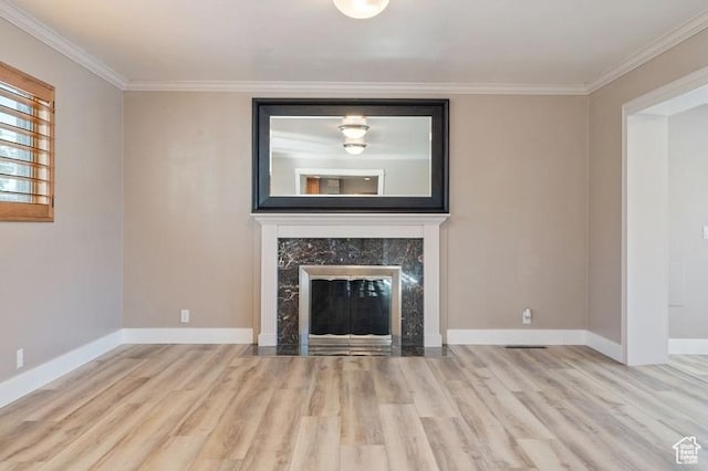 unfurnished living room featuring crown molding, light hardwood / wood-style flooring, and a premium fireplace