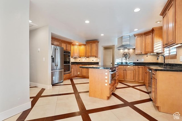 kitchen featuring sink, backsplash, a center island, stainless steel appliances, and wall chimney exhaust hood