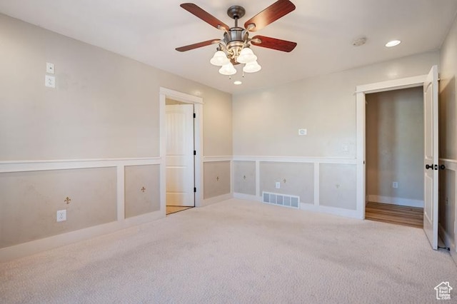 spare room with ceiling fan and light colored carpet