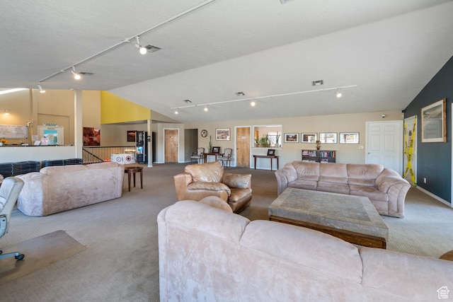 carpeted living room featuring lofted ceiling and track lighting
