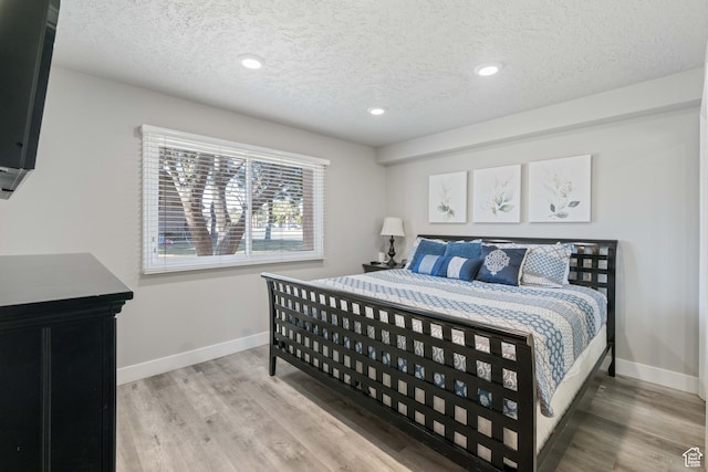 bedroom with hardwood / wood-style floors and a textured ceiling